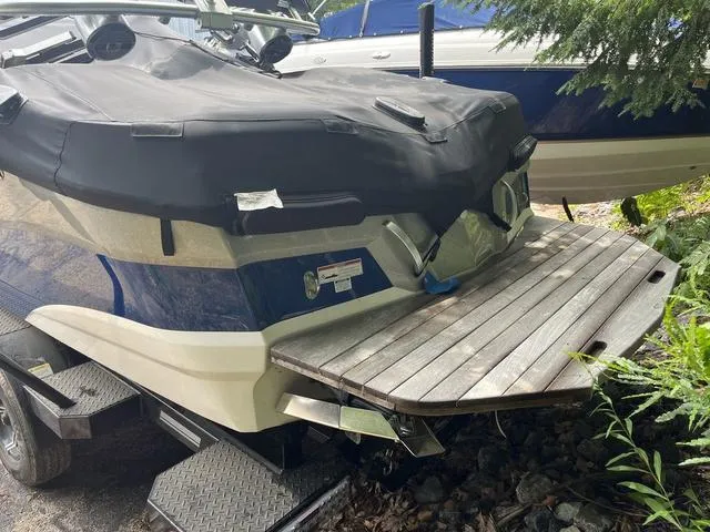 Slide: The Image of 2021 MasterCraft XT22 boat with cover on trailer, rear view, wooden swim platform. - 7