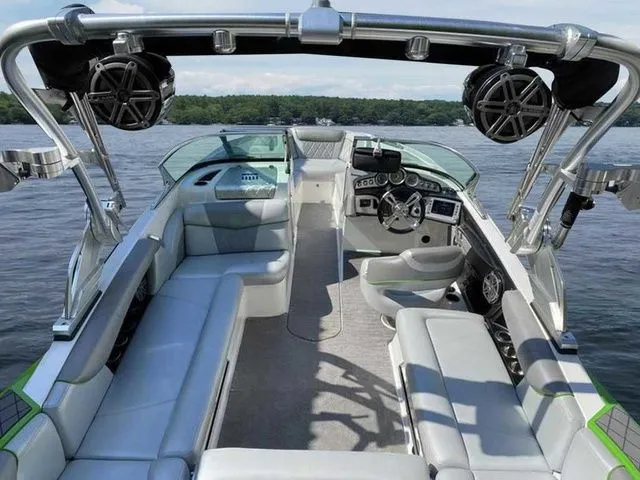 Slide: The Image of 2014 MasterCraft X30 boat interior with sleek seating and advanced controls on a lake. - 10