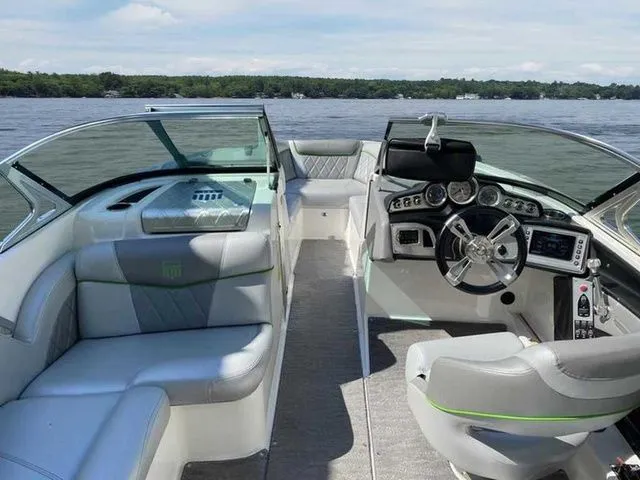 Slide: The Image of 2014 MasterCraft X30 boat interior with modern dashboard and seating on a lake. - 11