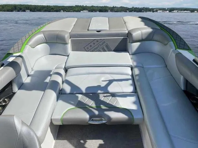 Slide: The Image of 2014 MasterCraft X30 boat interior with gray and green seating on a lake. - 17