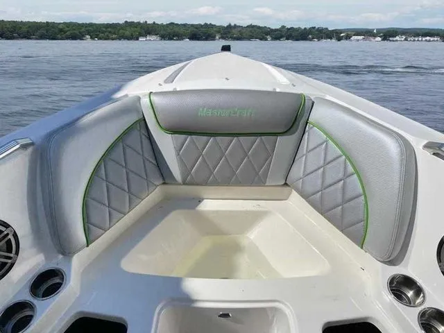 Slide: The Image of 2014 MasterCraft X30 boat interior with gray and green seating on a lake. - 20