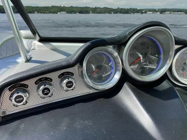 Slide: The Image of Dashboard of a 2014 MasterCraft X30 boat with gauges and controls, overlooking a lake. - 34