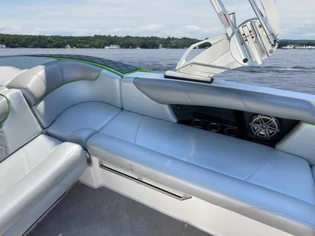 Slide: The Image of 2014 MasterCraft X30 boat interior with gray seating and speaker, on a lake. - 38