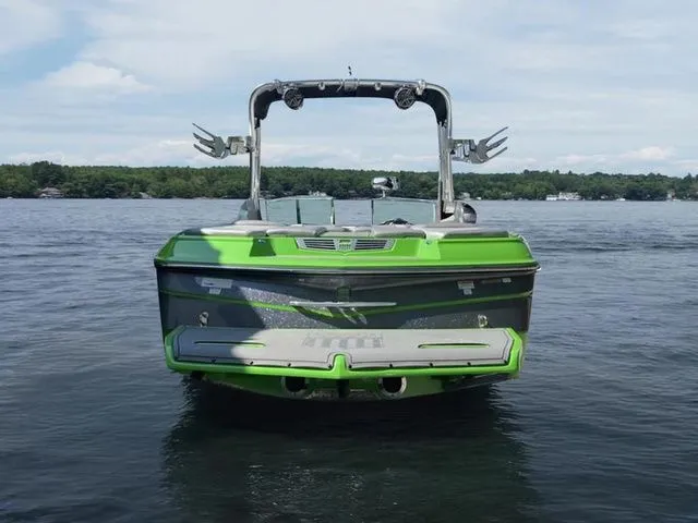 Slide: The Image of 2014 MasterCraft X30 boat on a lake, vibrant green color, rear view. - 4