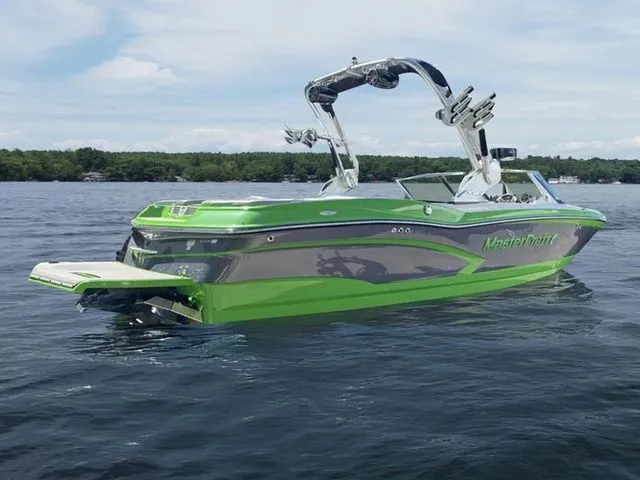 Slide: The Image of 2014 MasterCraft X30 boat in vibrant green on a calm lake. - 5