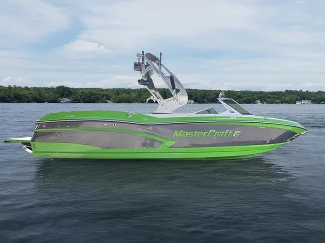 Slide: The Image of 2014 MasterCraft X30 boat in vibrant green on a calm lake. - 8