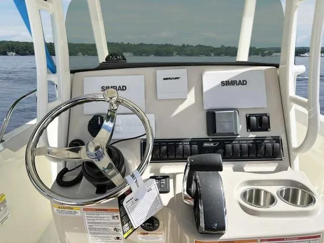 Slide: The Image of 2024 Boston Whaler 230 Outrage boat dashboard with steering wheel and Simrad electronics. - 12