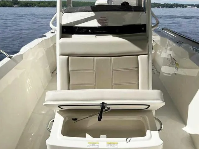 Slide: The Image of 2024 Boston Whaler 230 Outrage boat interior with open storage compartment on a sunny day. - 15