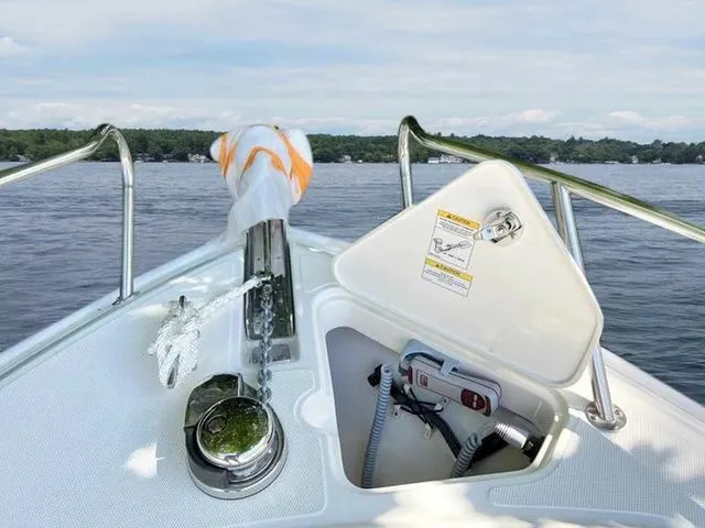 Slide: The Image of 2024 Boston Whaler 230 Outrage boat bow with anchor and lake view. - 20