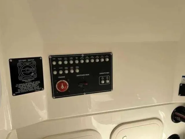 Slide: The Image of Control panel of 2024 Boston Whaler 230 Outrage boat, featuring switches and battery controls. - 21
