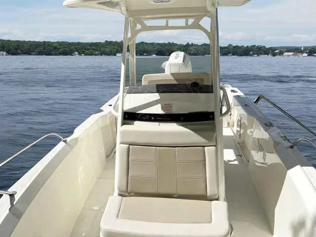 Slide: The Image of 2024 Boston Whaler 230 Outrage boat on calm water, featuring sleek design and spacious seating. - 7
