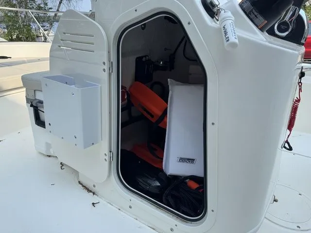 Slide: The Image of Open storage compartment on a 2025 Boston Whaler 170 Montauk boat, showing safety equipment. - 13