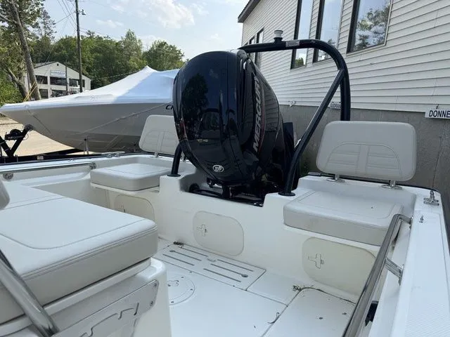 Slide: The Image of 2025 Boston Whaler 170 Montauk boat interior with Mercury engine, white seating, and outdoor setting. - 6