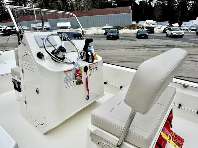 Slide: The Image of 2025 Boston Whaler 150 Montauk boat interior with steering console and seating. - 11