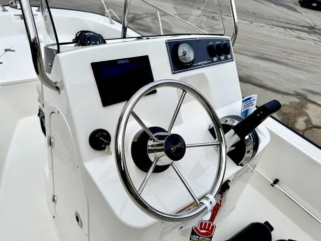 Slide: The Image of 2025 Boston Whaler 150 Montauk boat console with steering wheel and controls. - 12