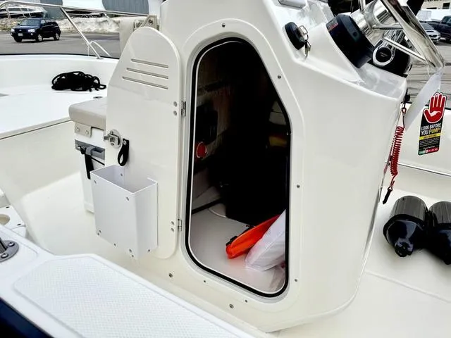 Slide: The Image of 2025 Boston Whaler 150 Montauk boat console with open storage compartment. - 13
