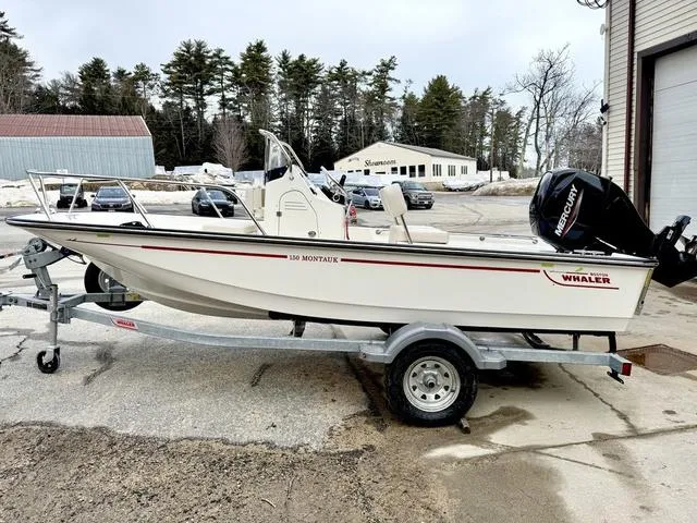 Slide: The Image of 2025 Boston Whaler 150 Montauk boat on trailer, parked outdoors. - 5
