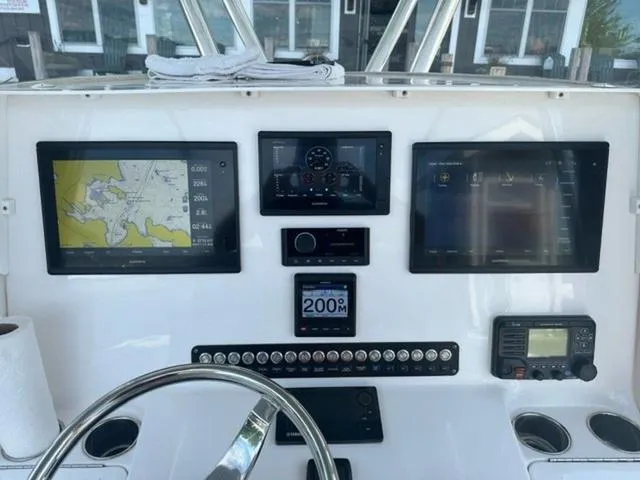 Slide: The Image of Control panel of a 2019 Contender 32ST boat with navigation screens and instruments. - 12