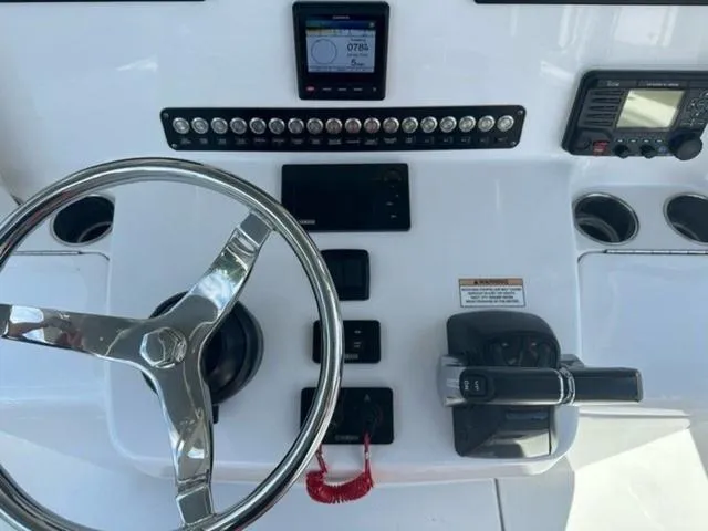 Slide: The Image of 2019 Contender 32ST boat dashboard with steering wheel, controls, and electronic displays. - 13