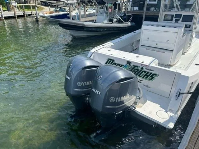 Slide: The Image of 2019 Contender 32ST boat with twin Yamaha 300 outboard engines docked in clear water. - 5