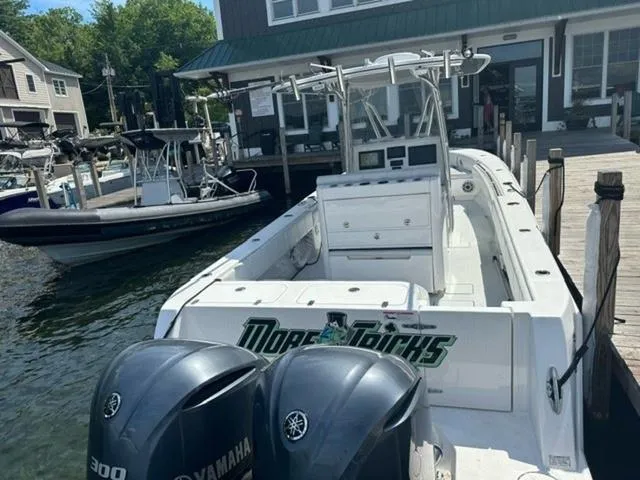 Slide: The Image of 2019 Contender 32ST boat docked, featuring twin Yamaha 300 engines, in a marina setting. - 6