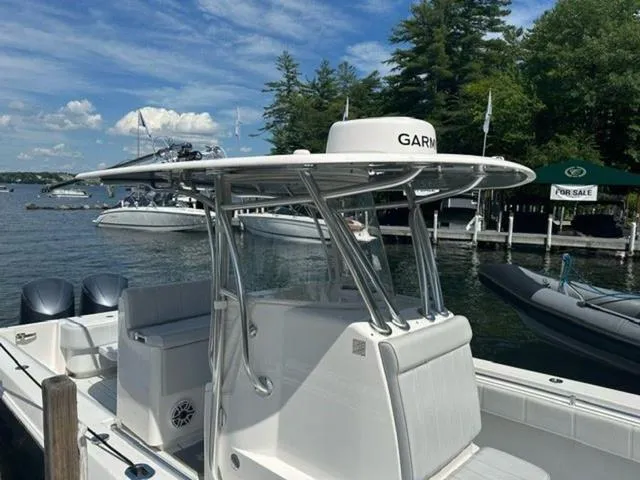 Slide: The Image of 2019 Contender 32ST boat docked by a lake with clear skies and trees. - 7