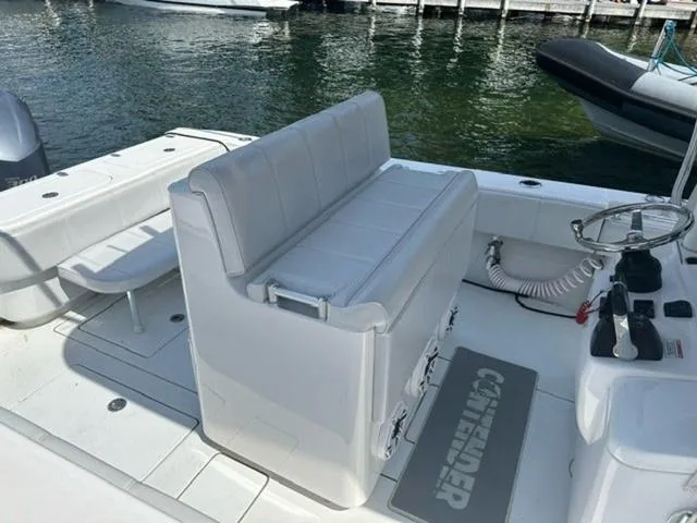 Slide: The Image of 2019 Contender 32ST boat interior with seating and steering wheel, docked by the water. - 9