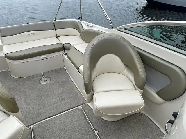 Slide: The Image of 2005 Sea Ray 240 Sundeck interior with cushioned seating and carpeted floor. - 13