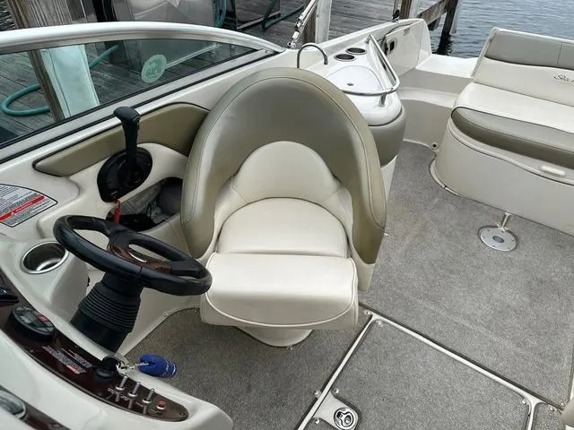 Slide: The Image of 2005 Sea Ray 240 Sundeck interior with helm, steering wheel, and seating. - 14