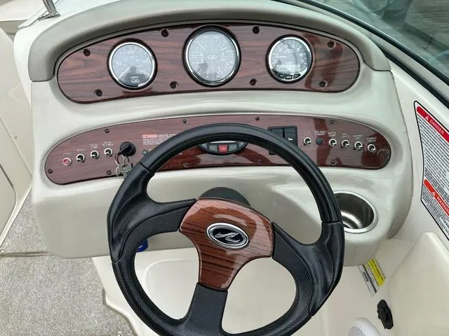 Slide: The Image of 2005 Sea Ray 240 Sundeck dashboard with wood accents and steering wheel. - 17