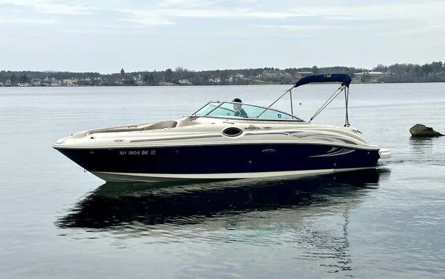 Slide: The Image of 2005 Sea Ray 240 Sundeck boat on calm water, featuring sleek design and blue canopy. - 5