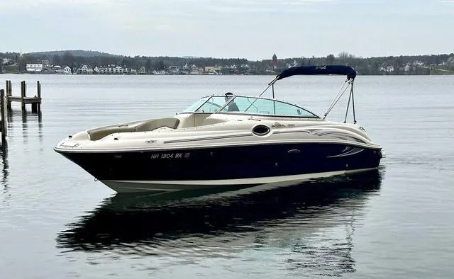Slide: The Image of 2005 Sea Ray 240 Sundeck boat on calm water with distant shoreline. - 6
