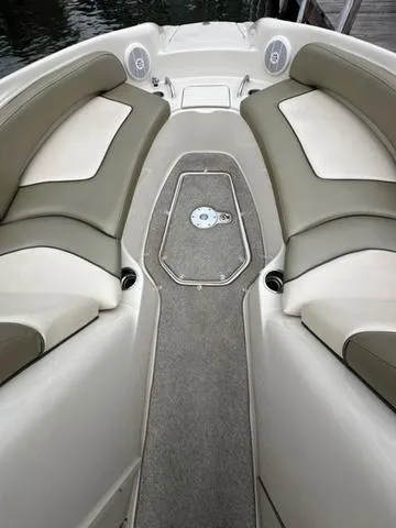 Slide: The Image of 2005 Sea Ray 240 Sundeck interior with cushioned seating and carpeted floor. - 8