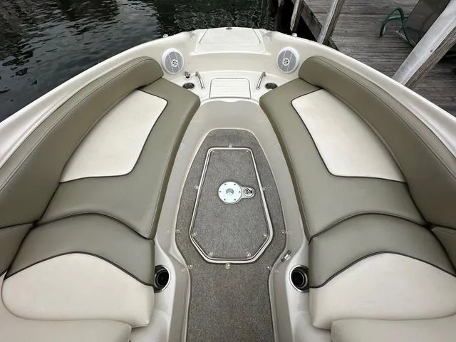Slide: The Image of 2005 Sea Ray 240 Sundeck boat interior with beige seating and carpeted floor. - 9