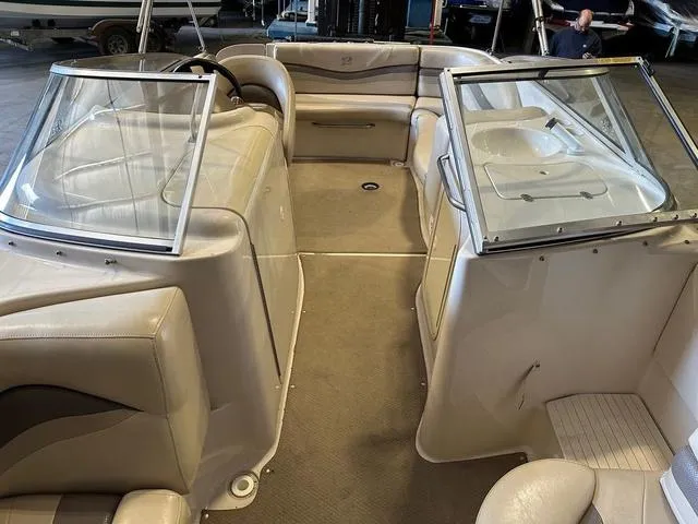 Slide: The Image of 2003 Larson 234 ESCAPE boat interior with beige seating and dual windshields. - 15