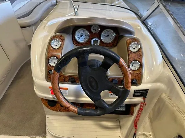 Slide: The Image of 2003 Larson 234 ESCAPE boat dashboard with steering wheel and gauges. - 7