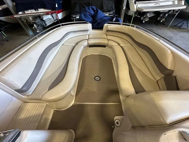 Slide: The Image of 2003 Larson 234 ESCAPE boat interior with beige seating and spacious layout. - 9