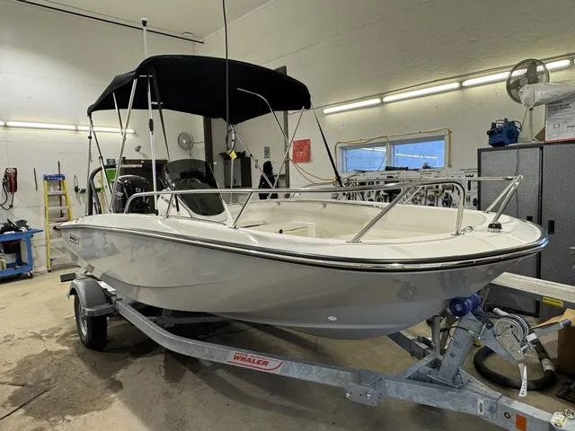 Slide: The Image of 2025 Boston Whaler 160 Super Sport boat in a garage, on a trailer. - 2