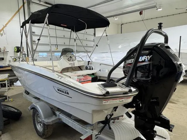 Slide: The Image of 2025 Boston Whaler 160 Super Sport boat with Mercury engine in a garage. - 6