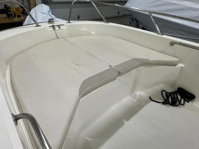 Slide: The Image of 2025 Boston Whaler 160 Super Sport boat interior with cushioned seating and railing. - 7