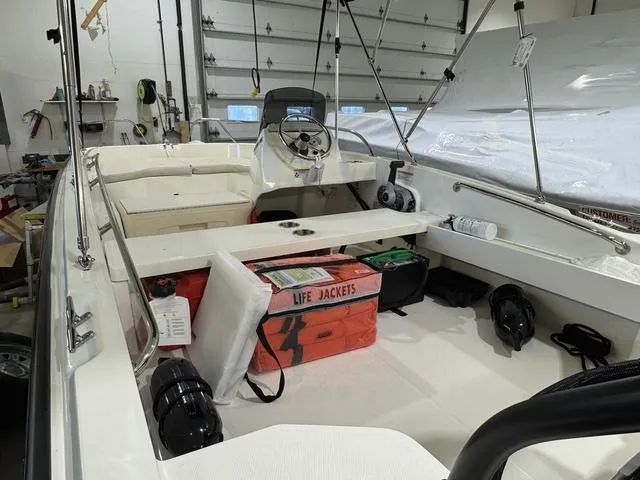 Slide: The Image of 2025 Boston Whaler 160 Super Sport interior with life jackets and equipment in a garage setting. - 9