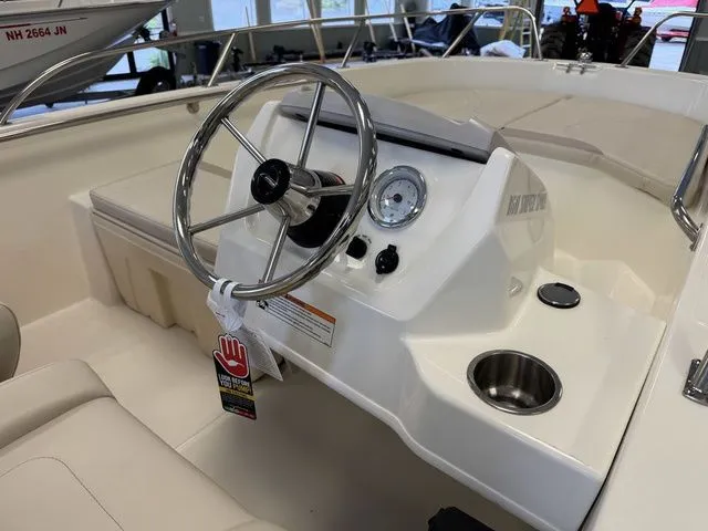 Slide: The Image of 2025 Boston Whaler 160 Super Sport boat dashboard with steering wheel and gauges. - 11