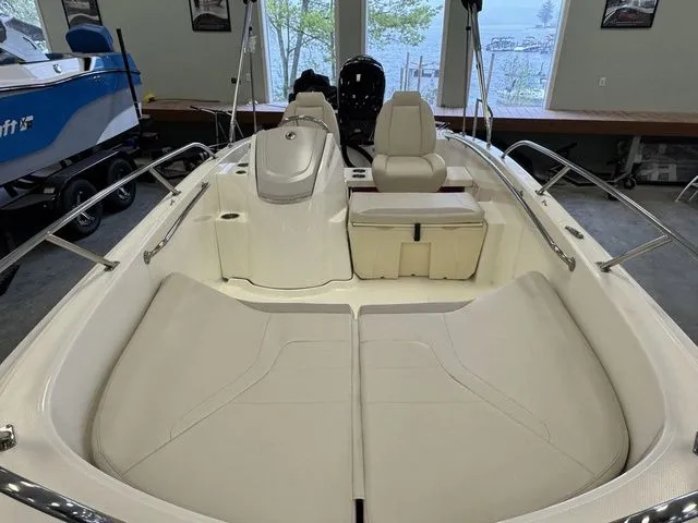 Slide: The Image of 2025 Boston Whaler 160 Super Sport boat interior with cushioned seating and steering console. - 16