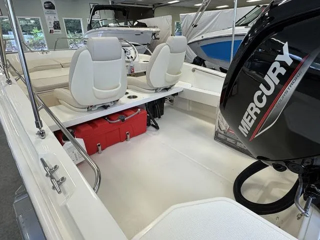 Slide: The Image of 2025 Boston Whaler 160 Super Sport boat interior with Mercury engine, white seating, and red cooler. - 8