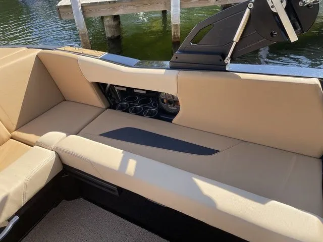 Slide: The Image of 2023 MasterCraft NXT22 boat interior with beige seating and cup holders. - 12