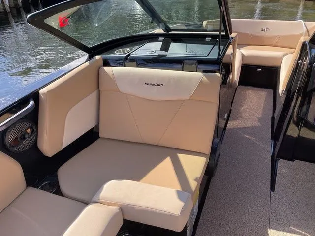 Slide: The Image of 2023 MasterCraft NXT22 boat interior with beige seating and sleek design. - 7