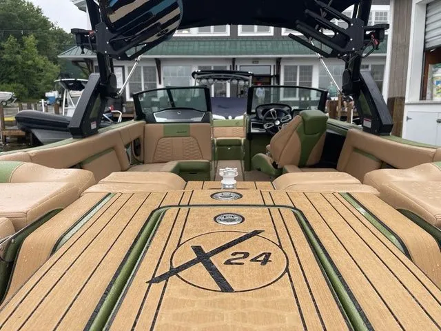 Slide: The Image of 2023 MasterCraft X24 boat interior with tan and green seating, showcasing luxury and style. - 10