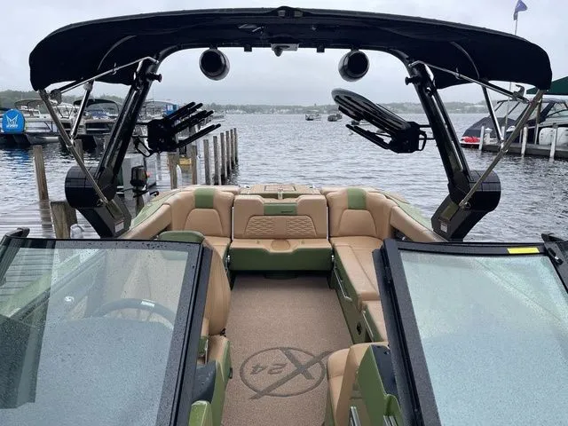 Slide: The Image of 2023 MasterCraft X24 boat interior with tan seating, black tower, and lake view. - 7