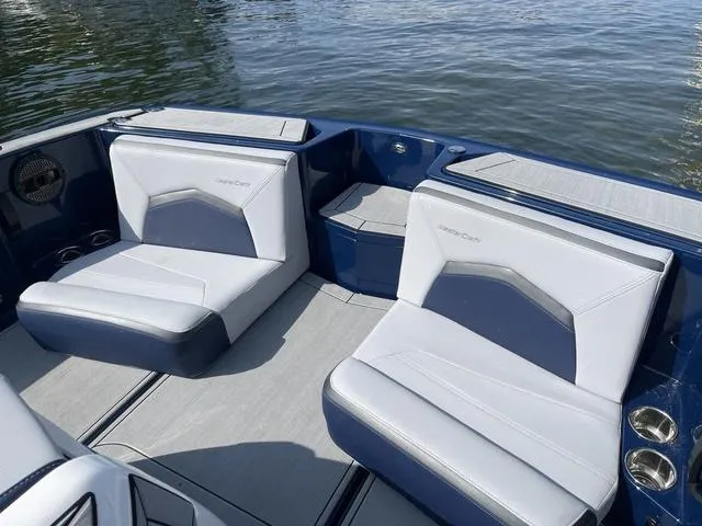 Slide: The Image of 2024 MasterCraft ProStar boat interior with sleek seating on calm water. - 11
