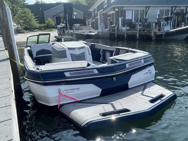 Slide: The Image of 2024 MasterCraft ProStar boat docked at marina, showcasing sleek design and spacious interior. - 4